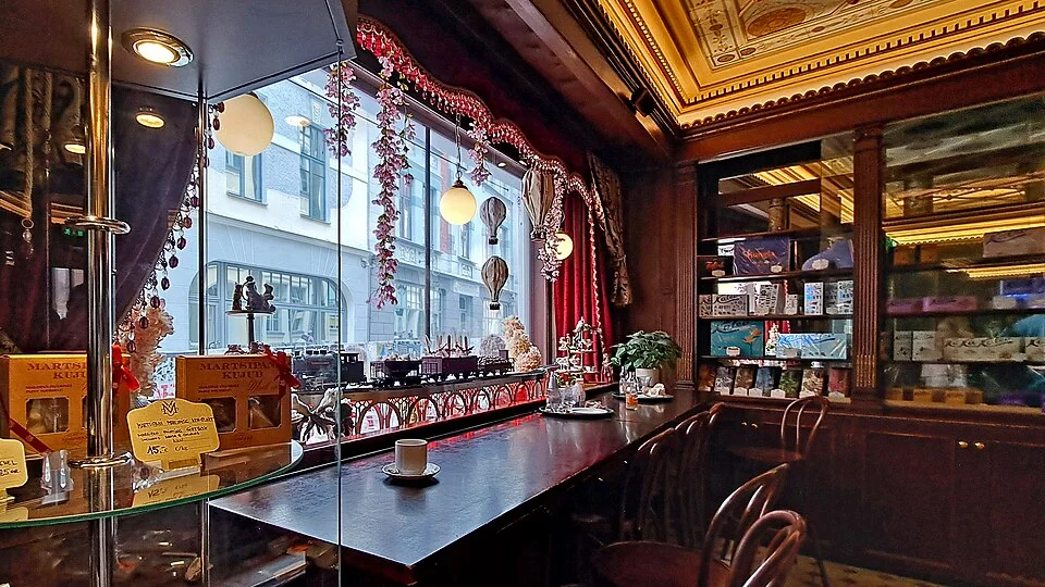 Wooden tables and decorative ceiling inside Tallinn’s Maiasmokk café